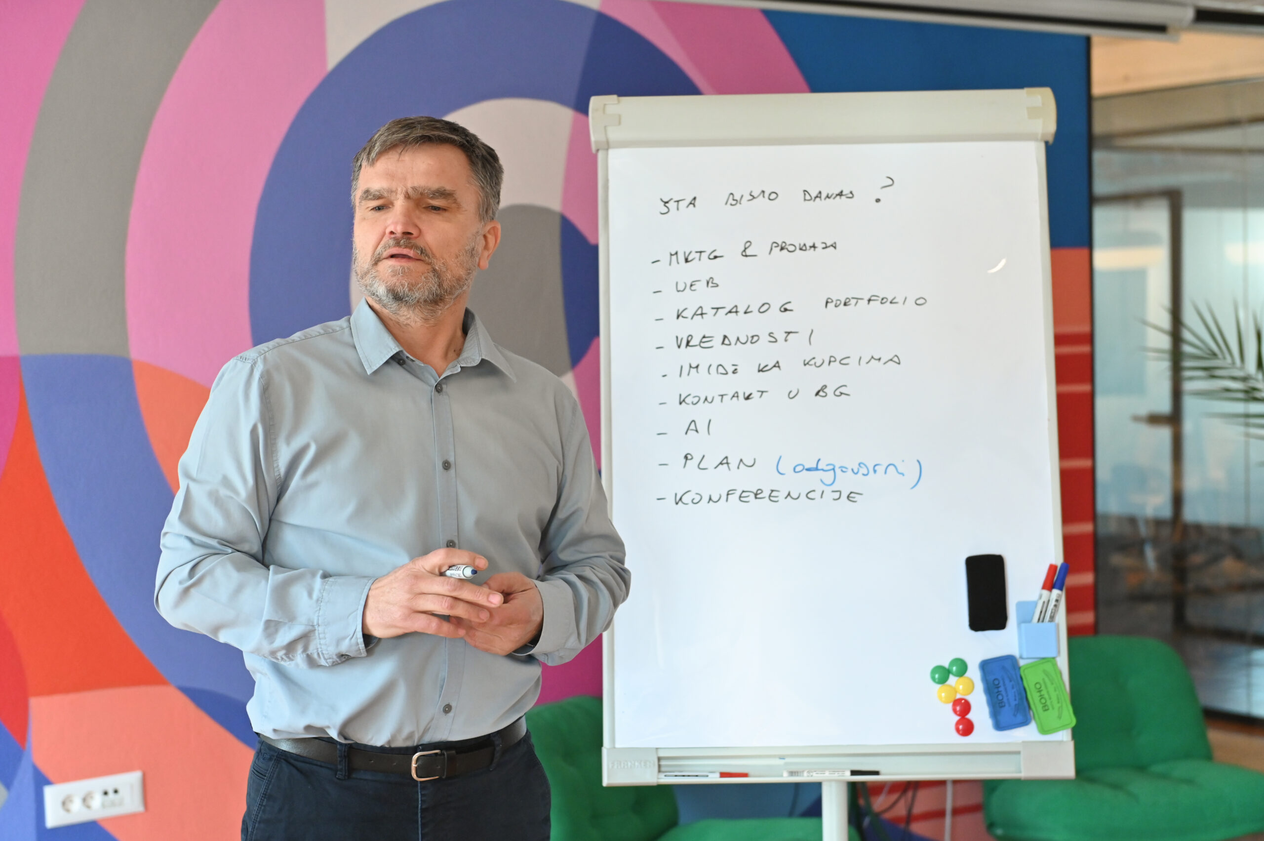 Svetovalec prikazuje proces na flipchartu med delavnico v proizvodnem okolju